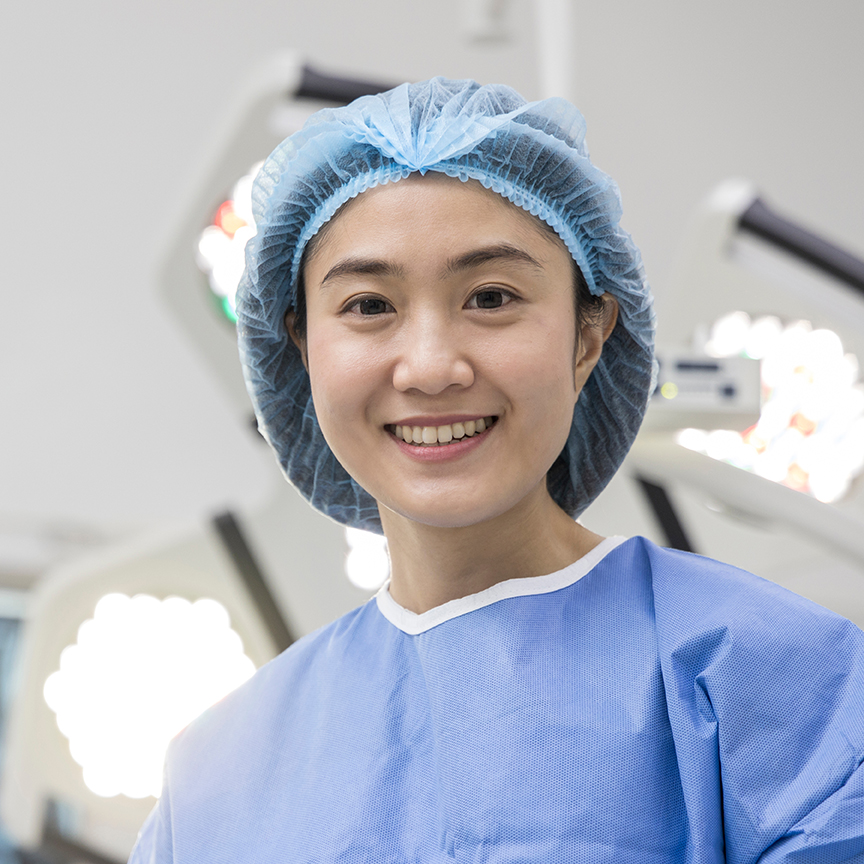 Female,Asian,Doctor,In,Blue,Surgical,Gown,Suit,Smiling,Inside
